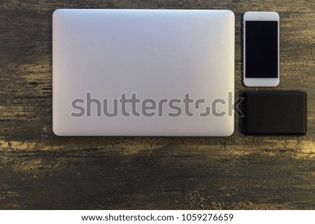 Top view of  table or desk with laptop, black hard disk and smart phone on old bronze background with copy space for text.