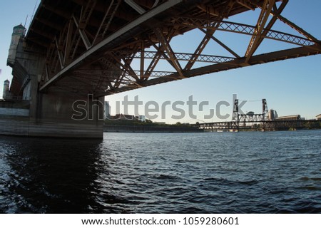Steel Bridge view under Burnside Bridge in Portland Oregon with Water Royalty-Free Stock Photo #1059280601