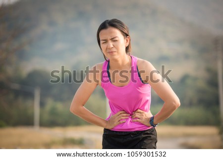 sport woman stomachache in a park in summer Royalty-Free Stock Photo #1059301532