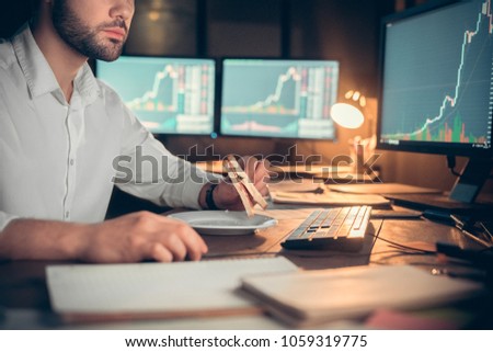 Young male trader at office work concept sitting holding sandwich close-up