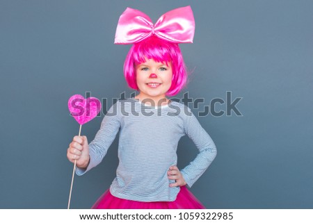 Happy valentine's day! Girl wearing pink suit holding heart