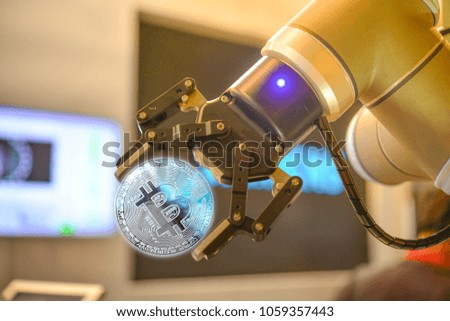 The mechanical arm holds the coin.