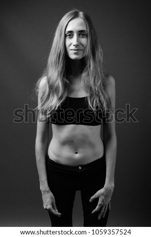 Studio shot of young beautiful woman ready for gym in black and white