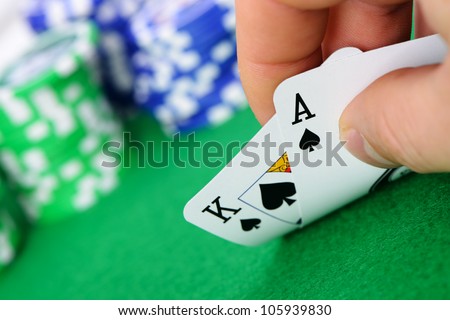 Gaming cards  in hand on the green cloth. A winning combination in Black Jack
