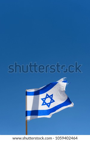 Israel flag close up image on a background of blue sky. White and blue colors. Israeli flag waving against clear blue sky. Independence day-Yom ha'atzmaut concept.Copy space.