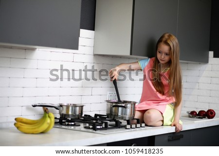 little girl in the kitchen posing at the camera