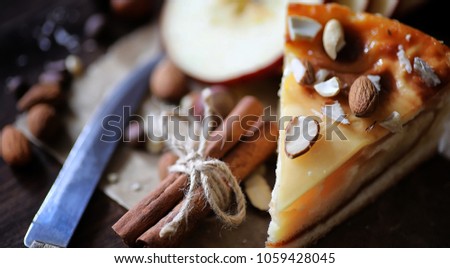 Pie with cinnamon and apples on a wooden table. Fresh pastry with cinnamon sticks with walnuts and sugar powder. Bun with nuts and cinnamon on table.