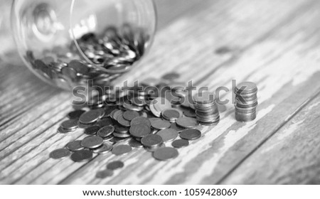 Coins in a jar on the floor. Accumulated coins on the floor. Pocket savings in piles.
