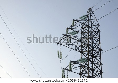 Power lines tower against the blue sky