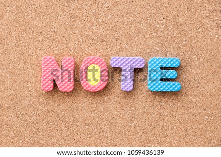 Color toy foam alphabet in word note on cork board background