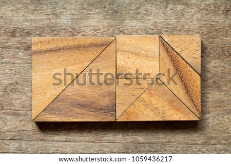 Tangram puzzle in rectangle shape on wood background