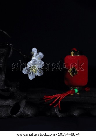 In a black background porcelain vase with white plum blossoms.