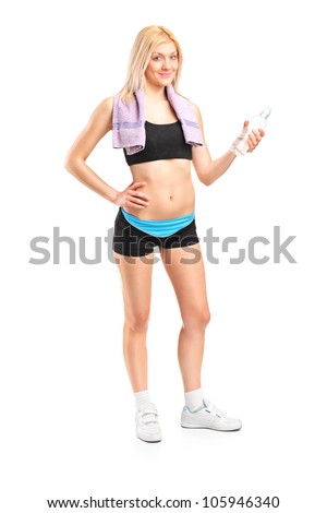 Full length portrait of an attractive sportswoman with a bottle of mineral water posing after a training isolated on white background
