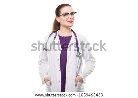 Attractive caucasian brunette female doctor standing in office smiling with hands in pockets