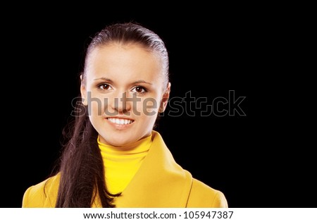 Portrait of smiling young beautiful woman in yellow coats and long hair, isolated on black background.