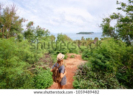 Tourism concept. Young traveling woman with rucksack enjoying sea view.