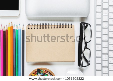 Mix of office supplies, laptop computer and mobile phone on contemporary table with other items. Above view. Mock up 