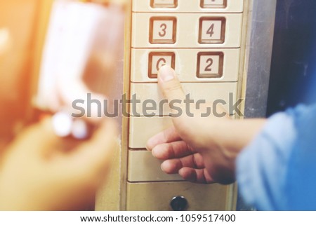 The hand presses on the old elevator button, Red button.  Close up shot and focus on button Old Elevator in a building at night