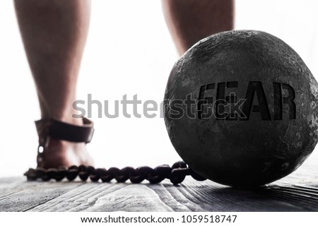 Fear is ball on the leg. Concept of fear.  Royalty-Free Stock Photo #1059518747