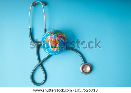 World health day ,Stethoscope wrapped around globe on pastel blue background. Save the wold, Global health care and Green Earth day concept