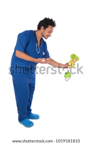 Doctor wearing his uniform holding a doll giving it to a kid to not be afraid, isolated on white background