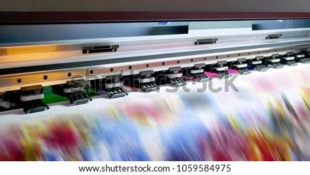 Large inkjet printing machine during production on vinyl banner. Royalty-Free Stock Photo #1059584975