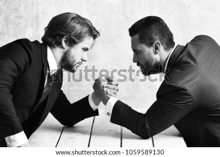 opposition of businessmen or men in suit, arm wrestling and power, business situation