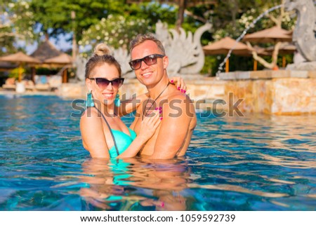Couple enjoying swimming pool in luxury resort