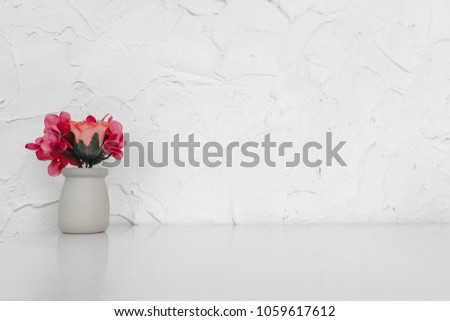 Mock up : Stylish minimalistic white table workplace with artificial flowers. copy space for product display montage.