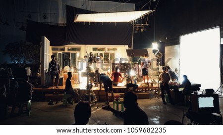 Blurry image of making movie video in big production studio and film crew team shooting or recording by professional digital camera and lighting set equipment. Royalty-Free Stock Photo #1059682235