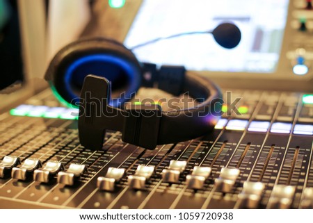 Professional audio Mixer and Professional Headphones in the Recording Studio. Sound Mixing Desk. Sound Mastering For Radio and TV Broadcast.
