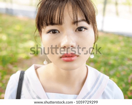 Portrait of beautiful Asian girl student in school uniform japanese style, looks a little sad and with tears in eyes.