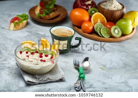 Breakfast still life with oatmeal porridge, fruits and coffee cup, top view, selective focus, shallow depth of field.