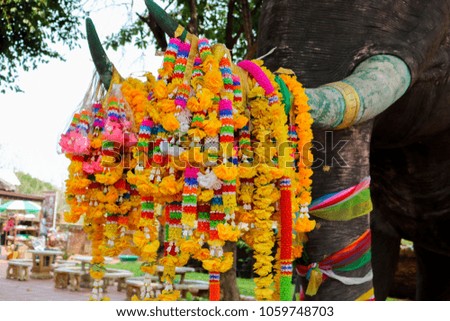 Yellow plastic steering wheel hanging on elephant statue