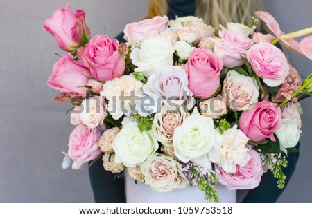 Beautiful blonde young woman holding big delicate bouquet of flowers roses carnation in rustic style