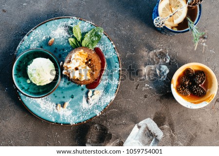 Desserts with ice cream served in different dishes on dark background 