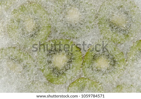 Ice covered green sliced kiwi. Closeup texture.
