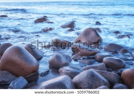 Scenic seascape natural background, Atlantic shore with waves and stones in sunset light