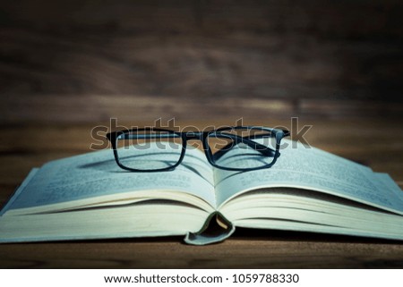 Books and glasses are on ancient boards