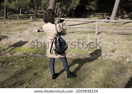 girl photographs flowers in the park