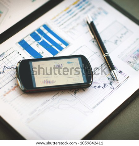 Business chart with smart phone and pen