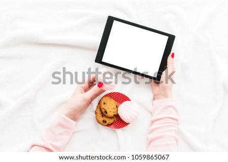 girl uses tablet pc, women's hands, lying on the blanket, white background with copy space, for advertising, top view