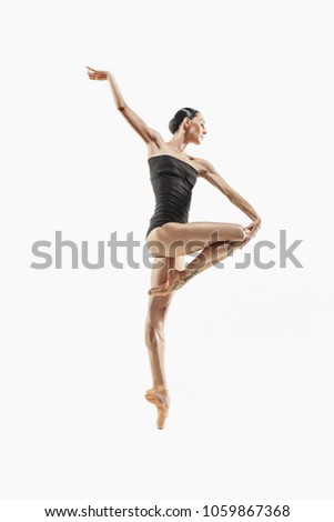 Modern ballet dancer exercising isolated in full body on white studio background. Ballerina or modern dancer in black swimsuit dancing on white studio background. Caucasian model on ballet pointe