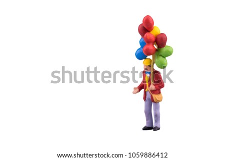 Close up of Miniature people with floating balloon isolated with clipping path on white background.