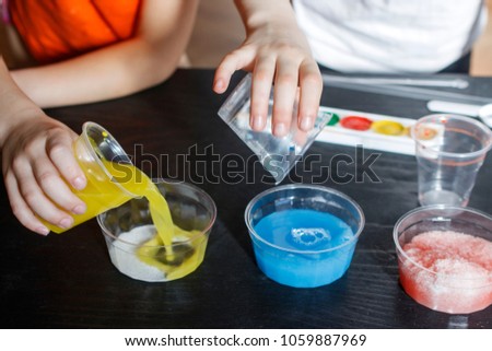 Children make experiments with paint and artificial snow