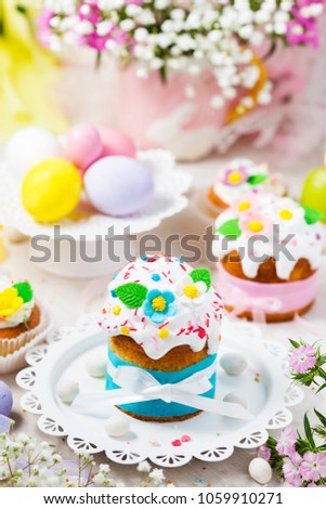 Traditional Easter cake with white icing decorated  sugar flowers and colorful eggs