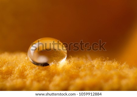 A drops dew water on the cloth golden orange blurred background