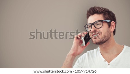 Male hipster using smart phone against brown background