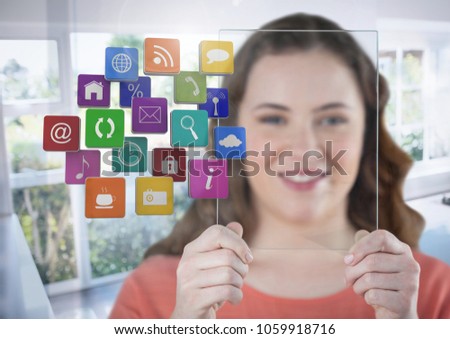 Woman holding glass screen with apps by sunny window