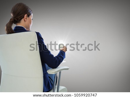Back of seated business woman drinking against grey background with flare